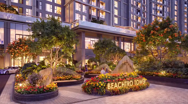 Cổng chào Beachtro Tower với bồn hoa nhiệt đới và vườn thư giãn trước sảnh tòa tháp về đêm