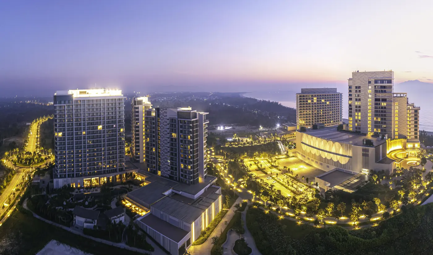 Hoiana Residences lúc hoàng hôn, hai tòa căn hộ lên đèn bên khách sạn và biển Hội An