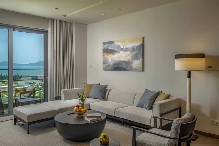 Phòng khách căn hộ Hoiana Residences bàn giao đủ nội thất, sofa lớn bên cửa kính