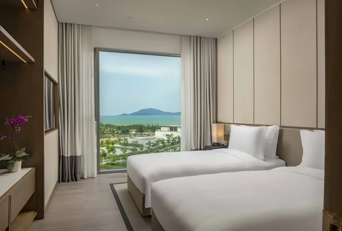 Phòng ngủ hai giường đơn của căn hộ 2 phòng ngủ Hoiana Residences, nhìn ra núi và biển