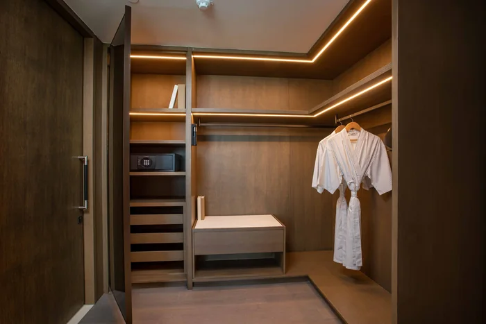 Phòng thay đồ có tủ gỗ, áo choàng và két an toàn trong căn hộ Hoiana Residences