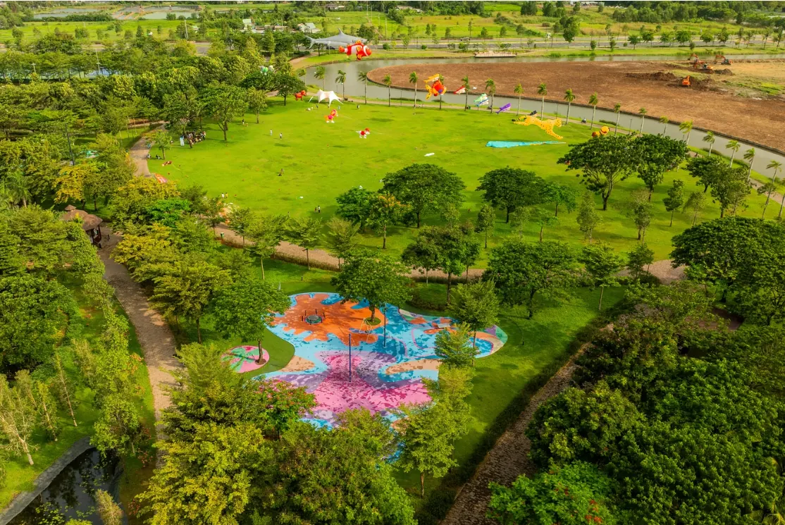Công viên bờ sông trong khu đô thị Waterpoint gần Rivera Nagomi, bãi cỏ rộng, hàng cây và lối dạo