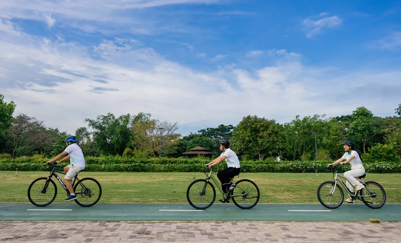 Cư dân đạp xe trên đường dành riêng cho xe đạp cạnh bãi cỏ trong khu đô thị Waterpoint