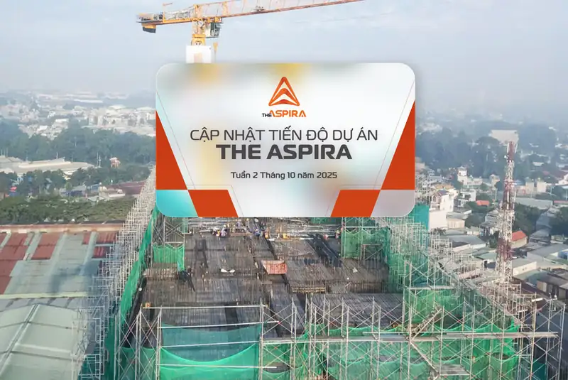 Bảng cập nhật tiến độ trên công trường The Aspira, phía sau là khu dân cư hiện hữu