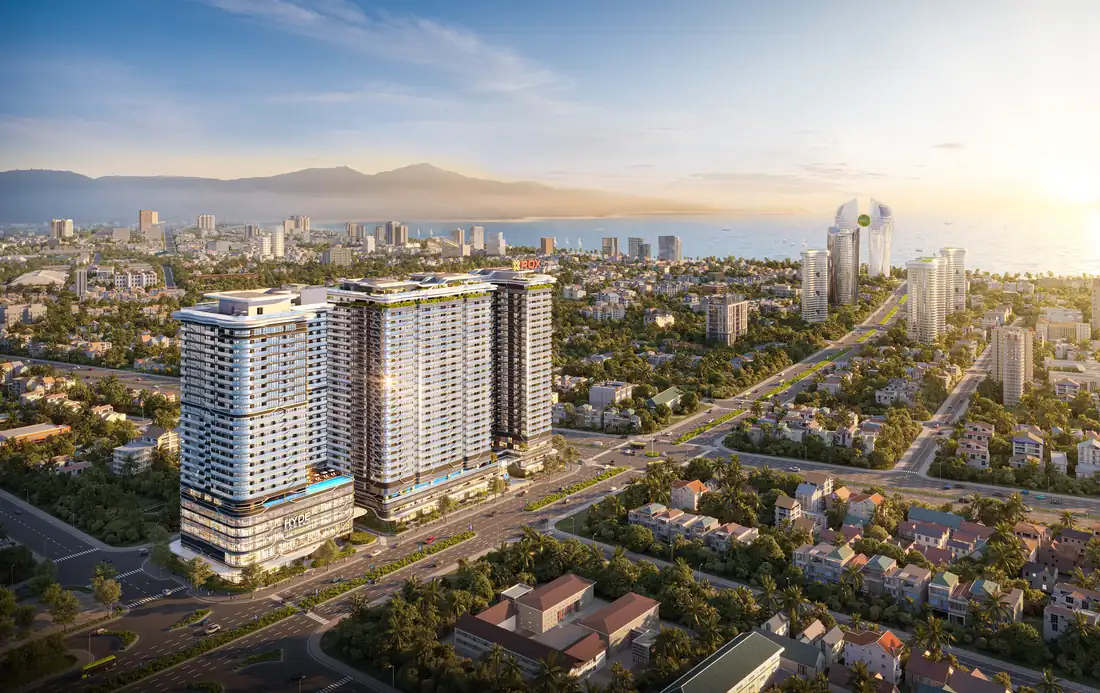 The Legend Đà Nẵng trong bình minh: hai tòa tháp giữa phố, phía xa là biển và dãy núi