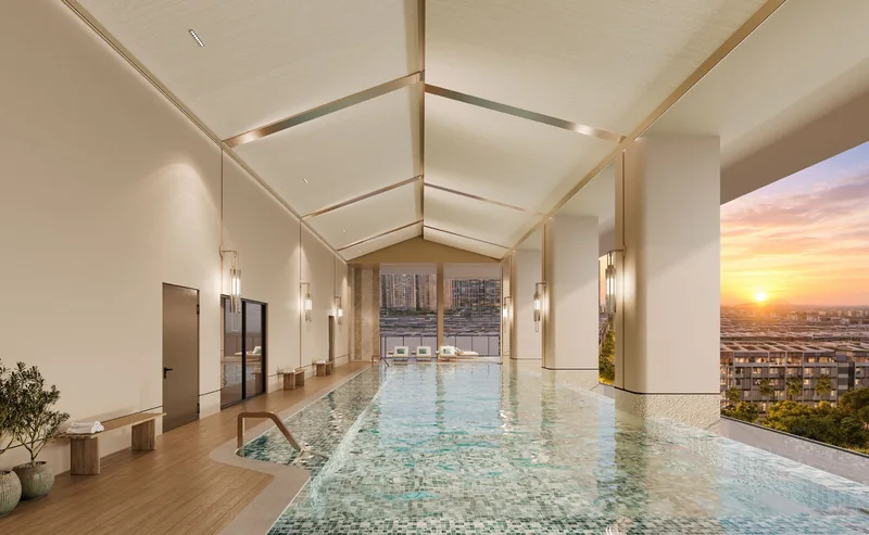 Hồ bơi tầng 4 The Westique Residences: lòng hồ dài dưới mái dốc, vách kính nhìn ra thành phố lúc hoàng hôn