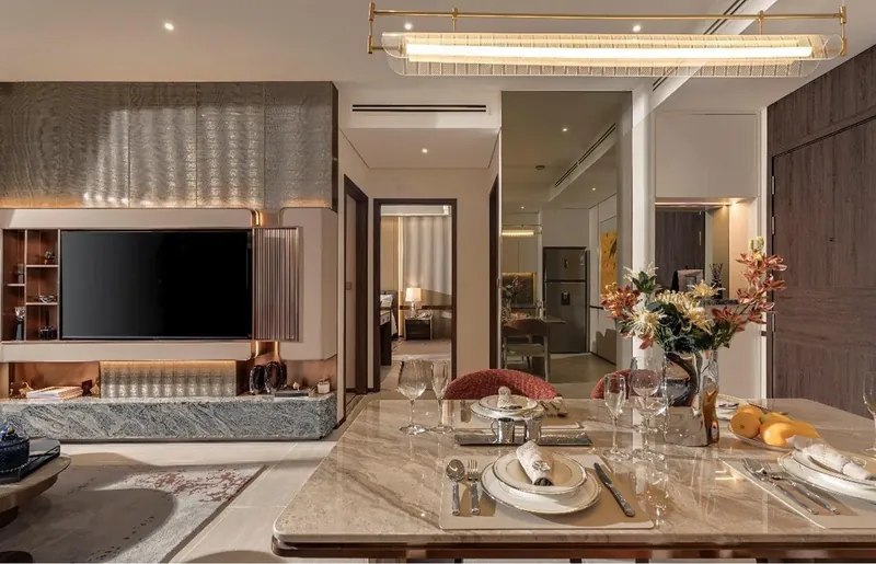 Bếp và phòng ăn căn hộ mẫu The Westique Residences: bàn ăn đá, tủ bếp liền tường và khu tiếp khách